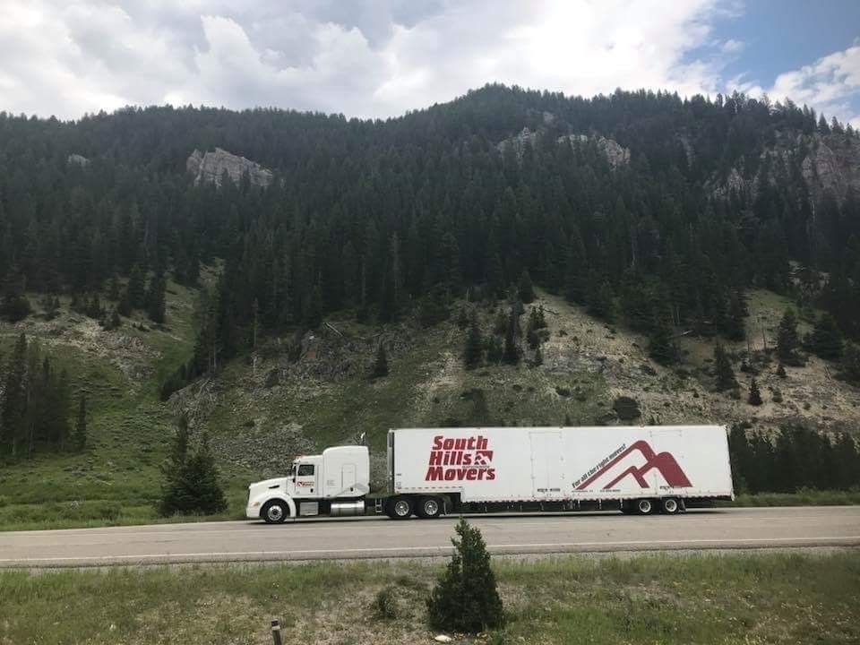 Semi-truck on a road in front of a mountain. The truck has the