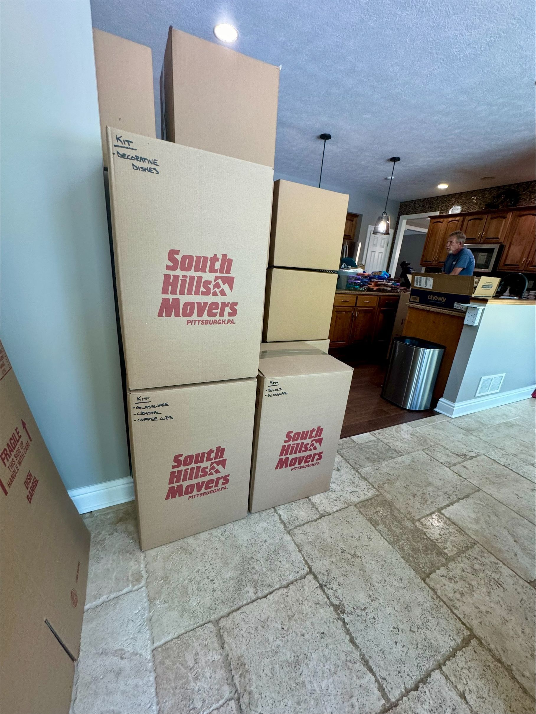 Cardboard moving boxes stacked in a home, one labeled