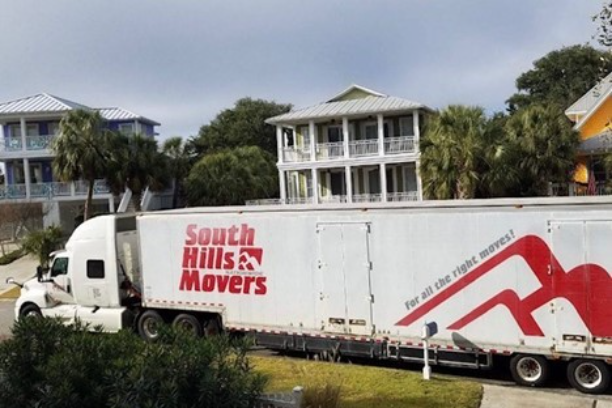 White South Hills Movers truck parked near two-story beach houses.