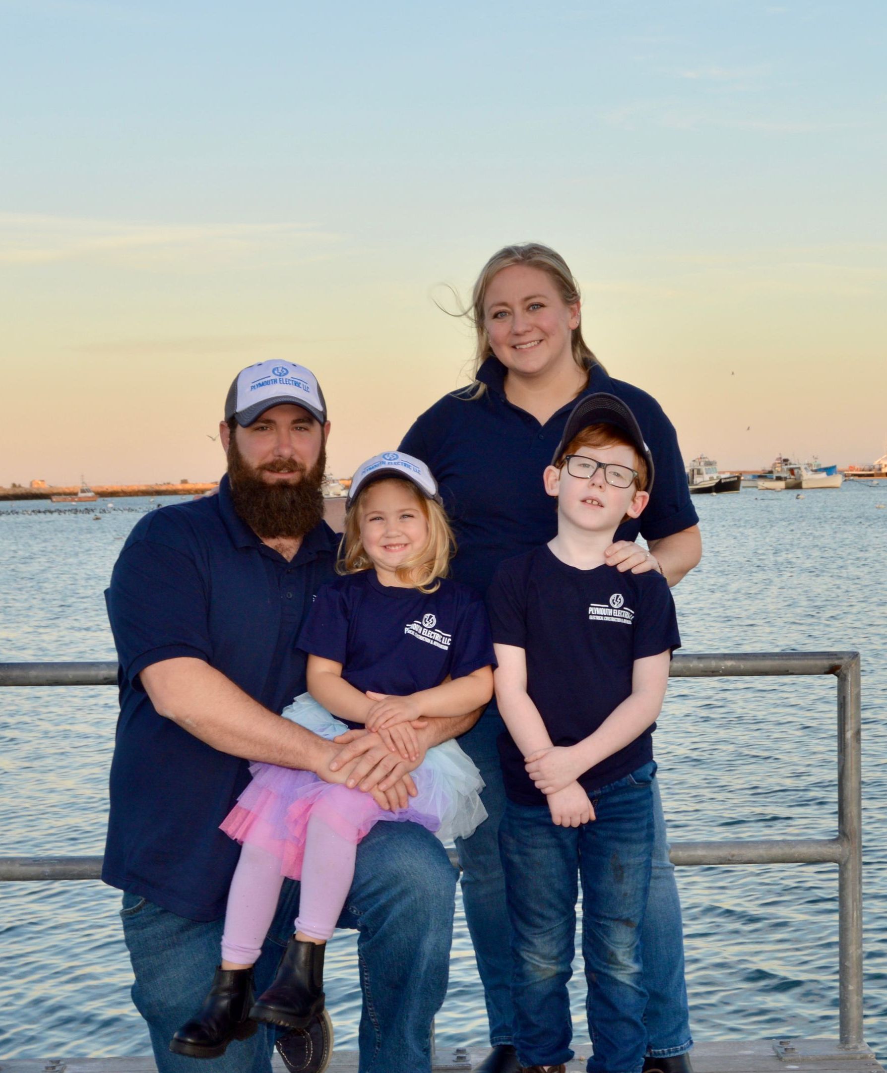 A family poses for a picture on a dock near the water