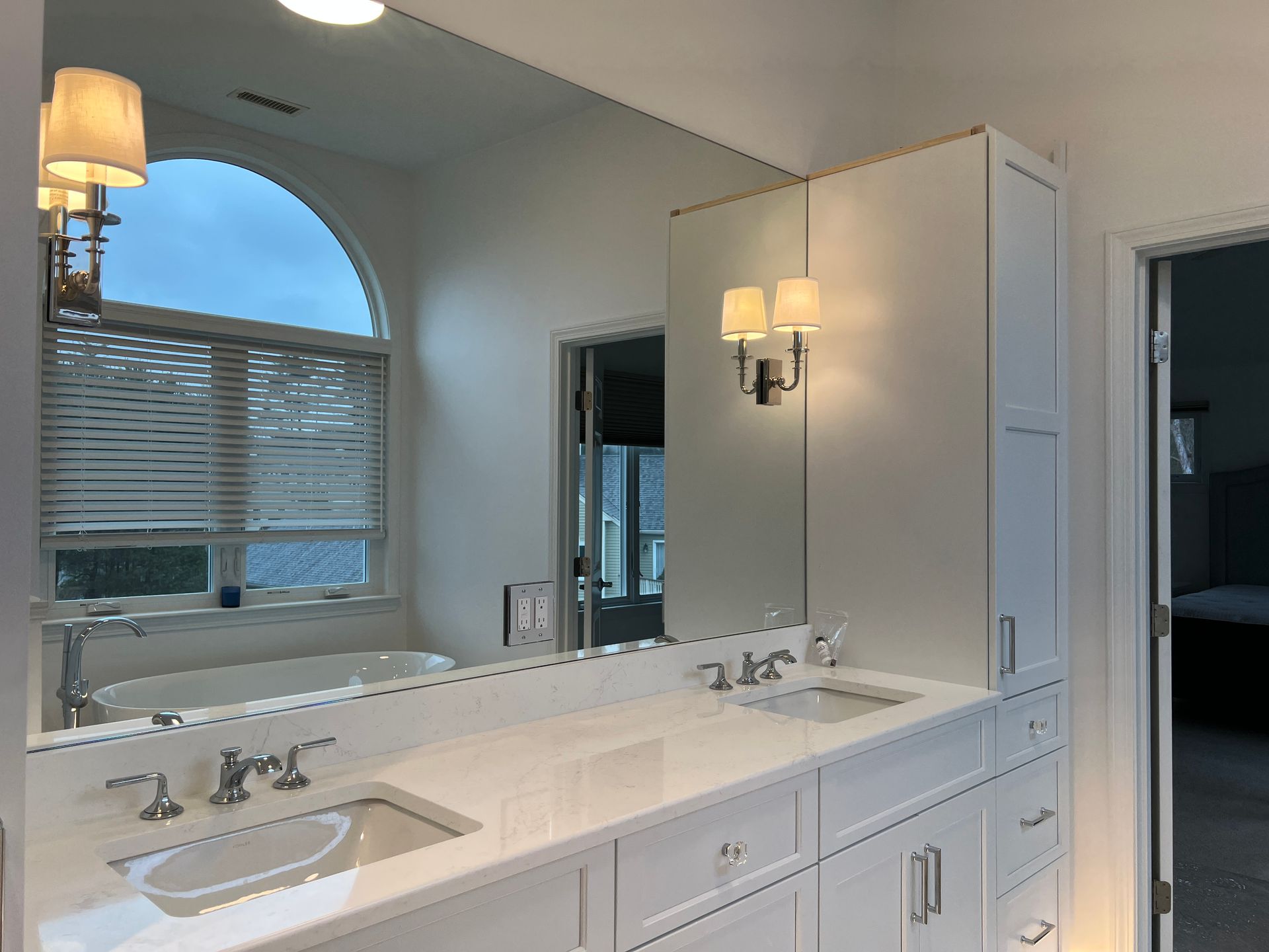 A bathroom with two sinks and a large mirror.