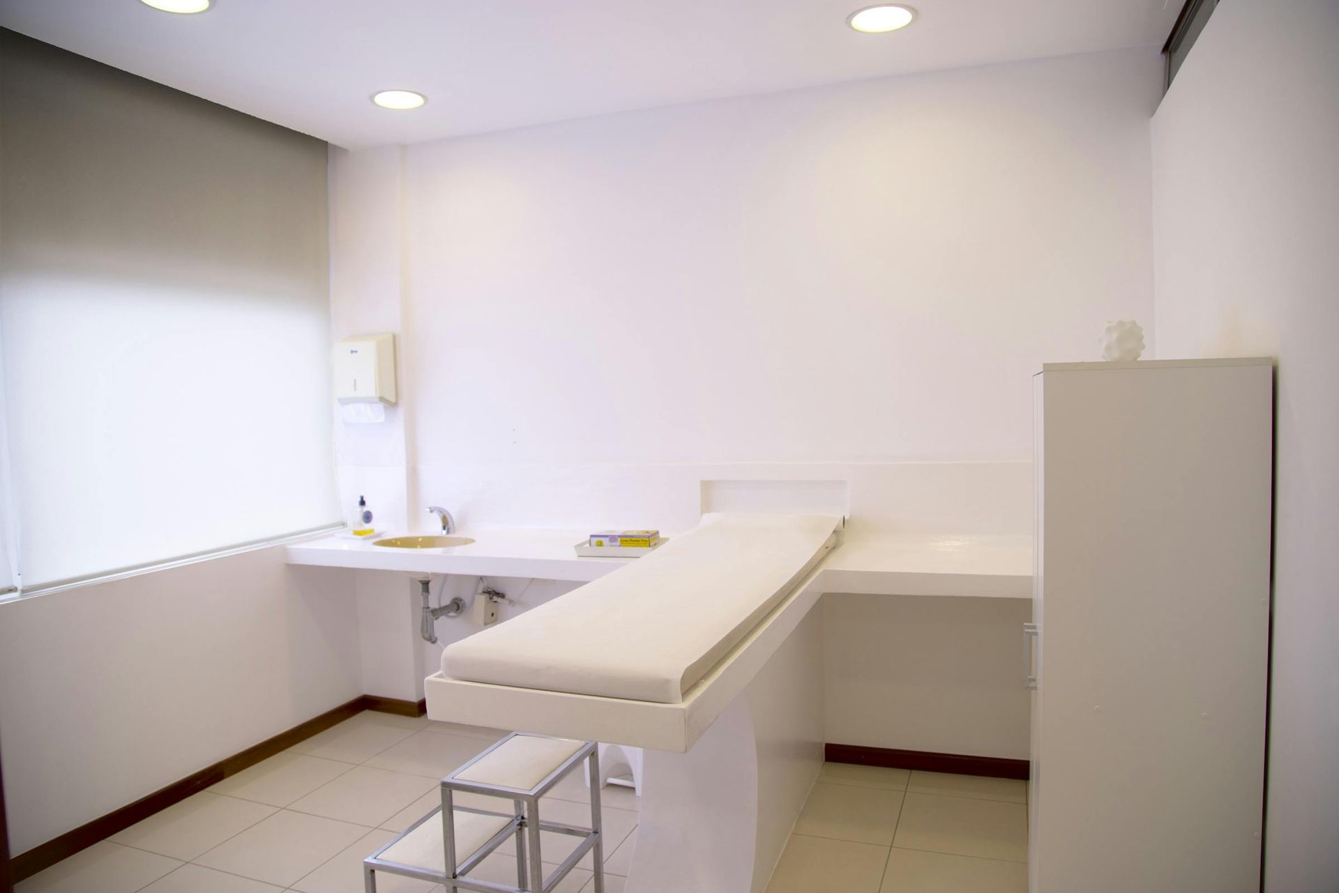 Examination room with white walls, examination table, and window.