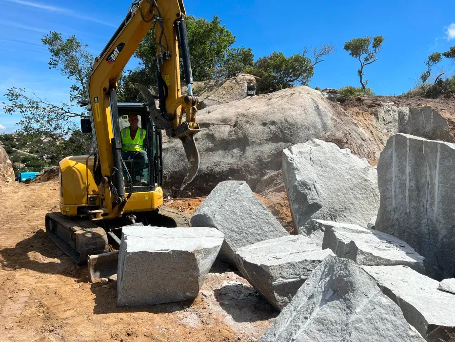 Construction site with three CAT machines: excavator, skid steer, and track loader.
