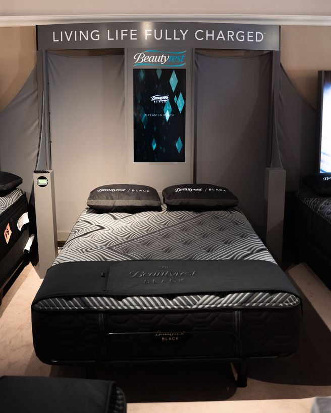 A bed with a sign that says living life fully charged