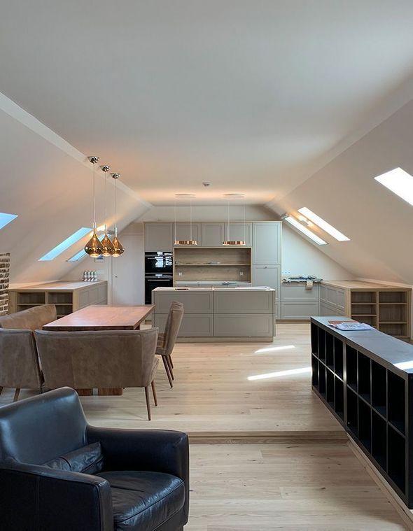 Helles, modernes Dachgeschoss-Wohn- und Esszimmer mit Oberlichtern, hellen Holzböden und grauen Möbeln