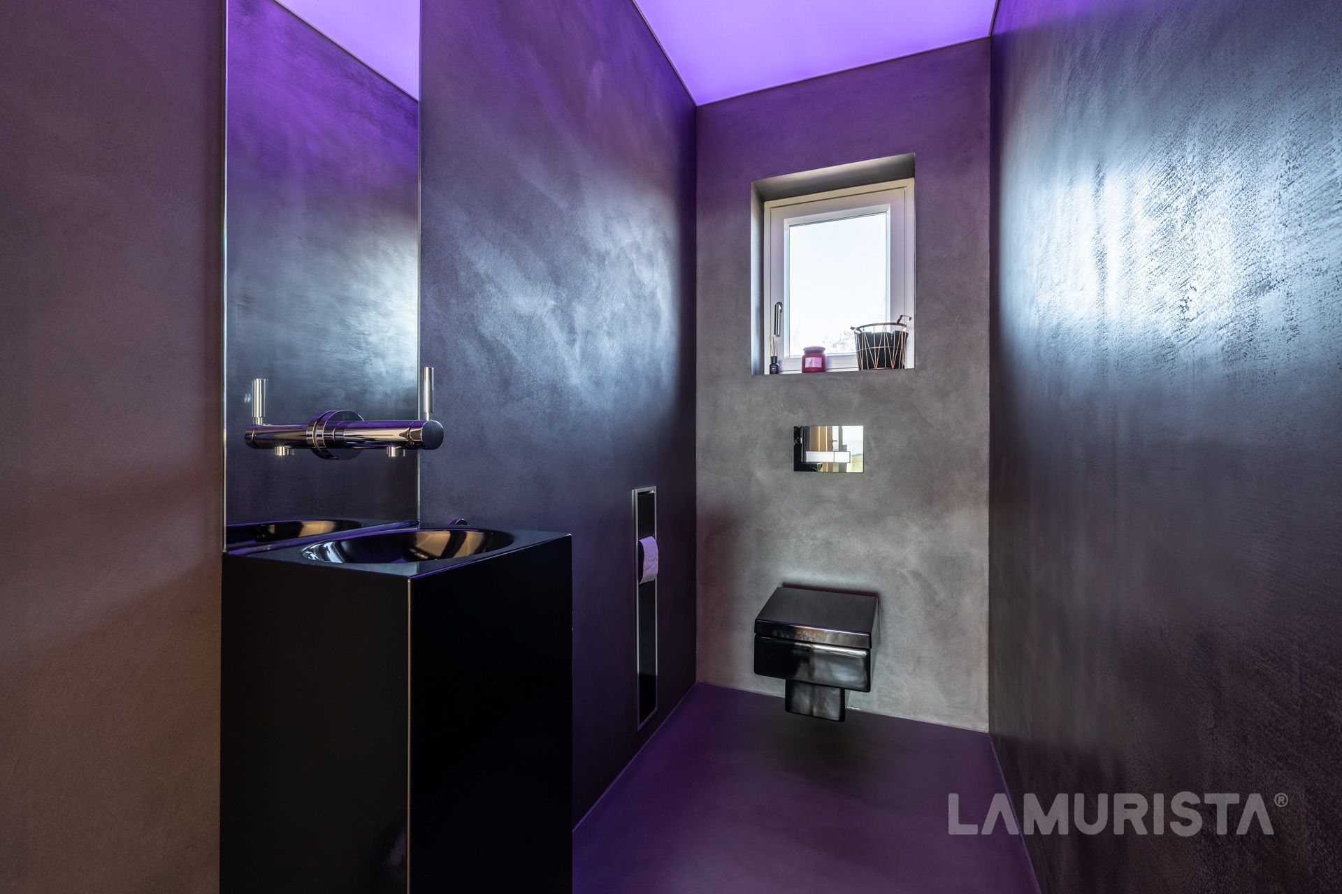 Modernes Badezimmer in Lila und Grau mit schwarzem Waschtisch und kleinem Fenster.