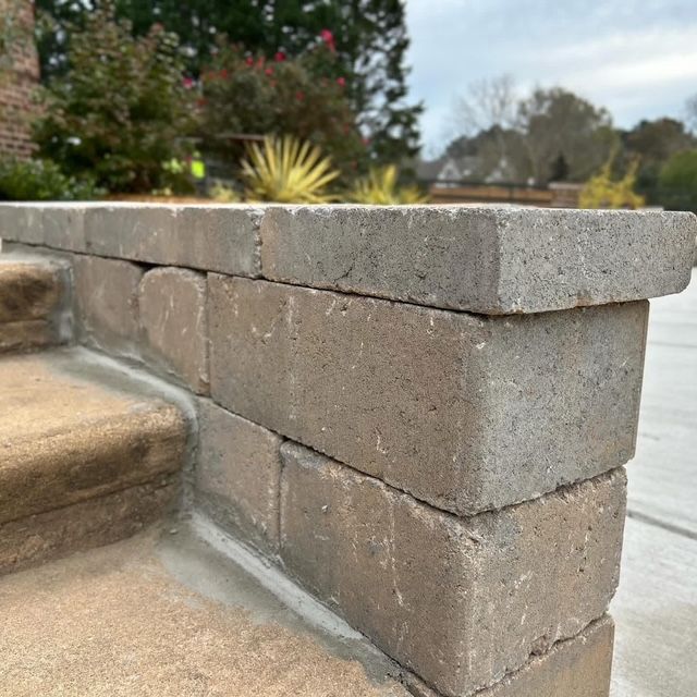 Stone retaining wall beside outdoor steps in a garden or yard