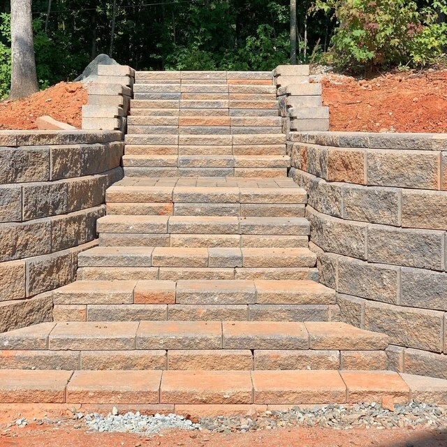 Stone staircase between retaining walls in a landscaped outdoor area