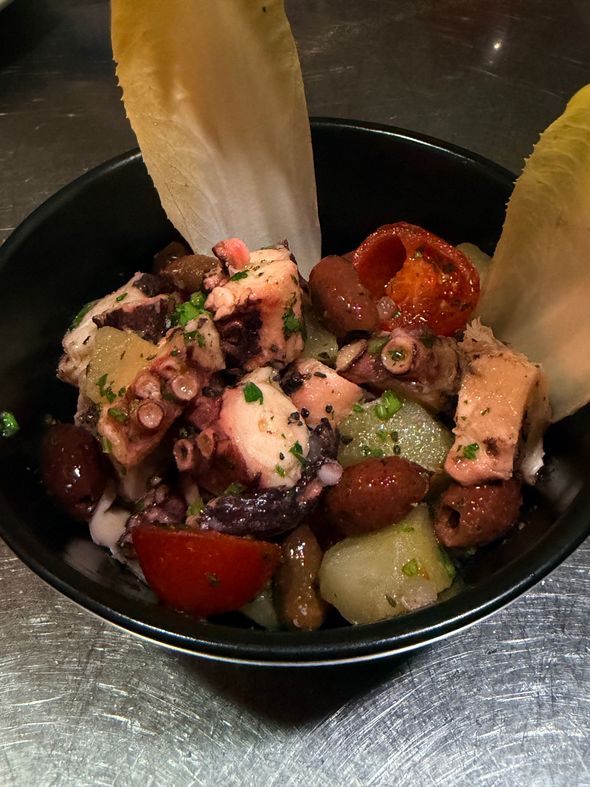 Poke bowl di salmone con avocado, cetriolo, pomodori e guarnizione croccante in una ciotola nera
