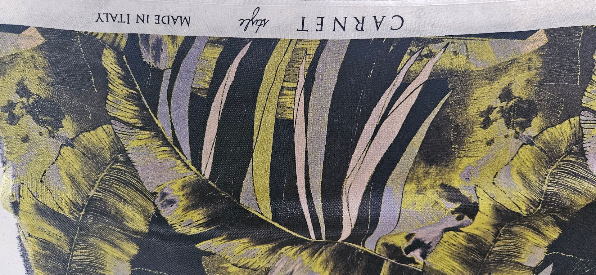 Abstract zwart-geel gestreept patroon met bovenaan een klein wit label.