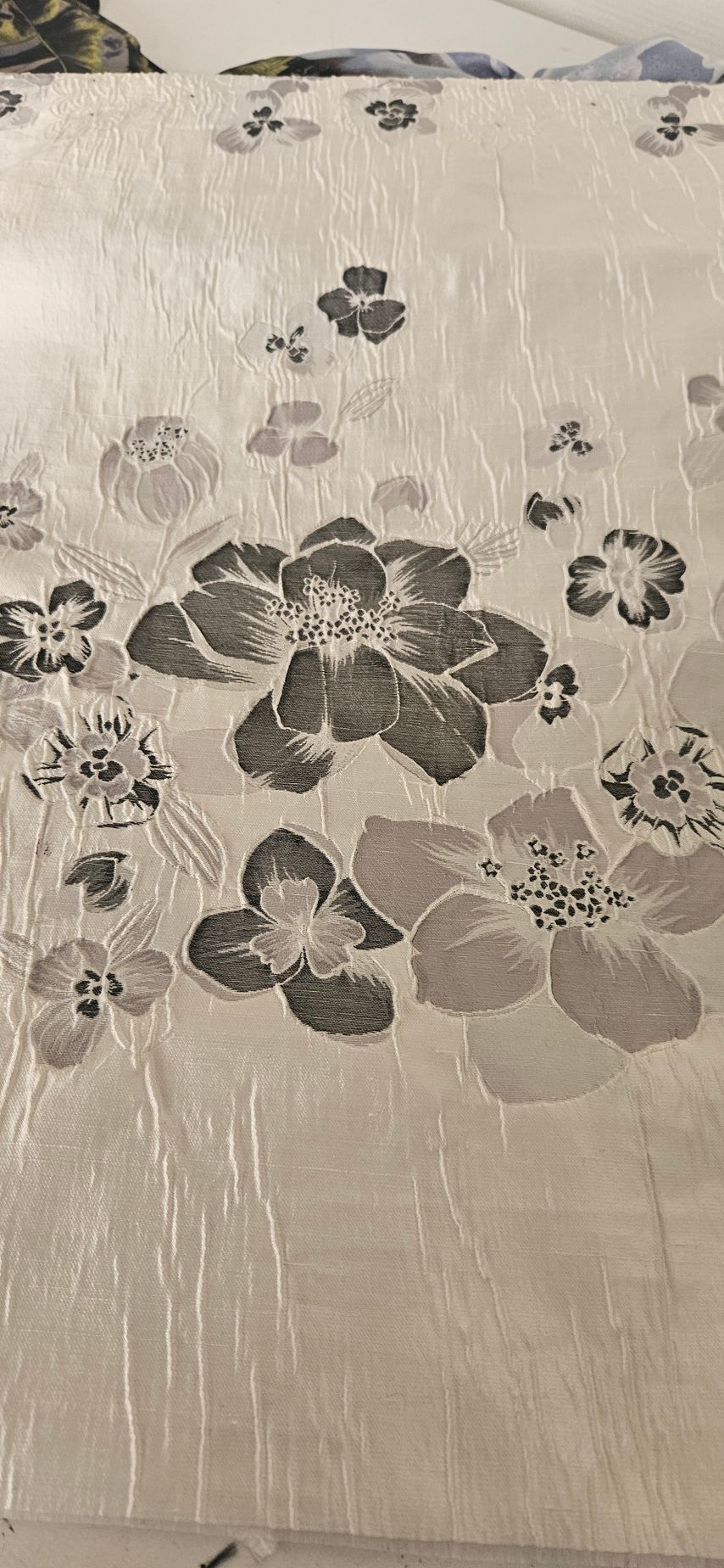 Grijze stof met bloemenprint, met grote en kleine bloesems op een lichte achtergrond