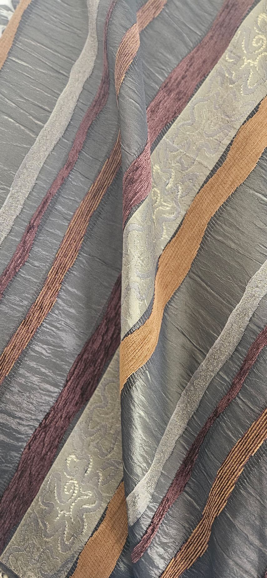 Close-up van veelkleurige gestreepte stof met grijze, blauwe, kastanjebruine en beige patronen