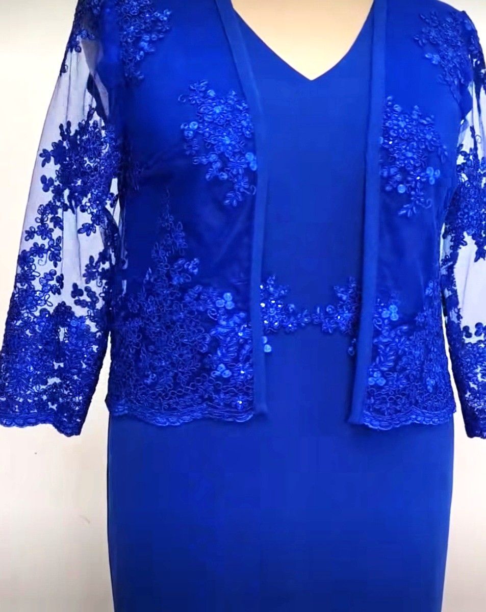 Een vrouw draagt ​​een feestelijke blauwe jurk en een blauw jasje