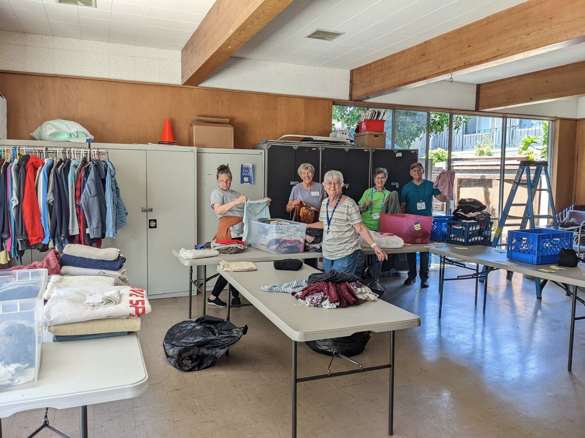 Saturday Homeless Shower Volunteers | Voluntario del program de duchas arreglando la ropa para dar