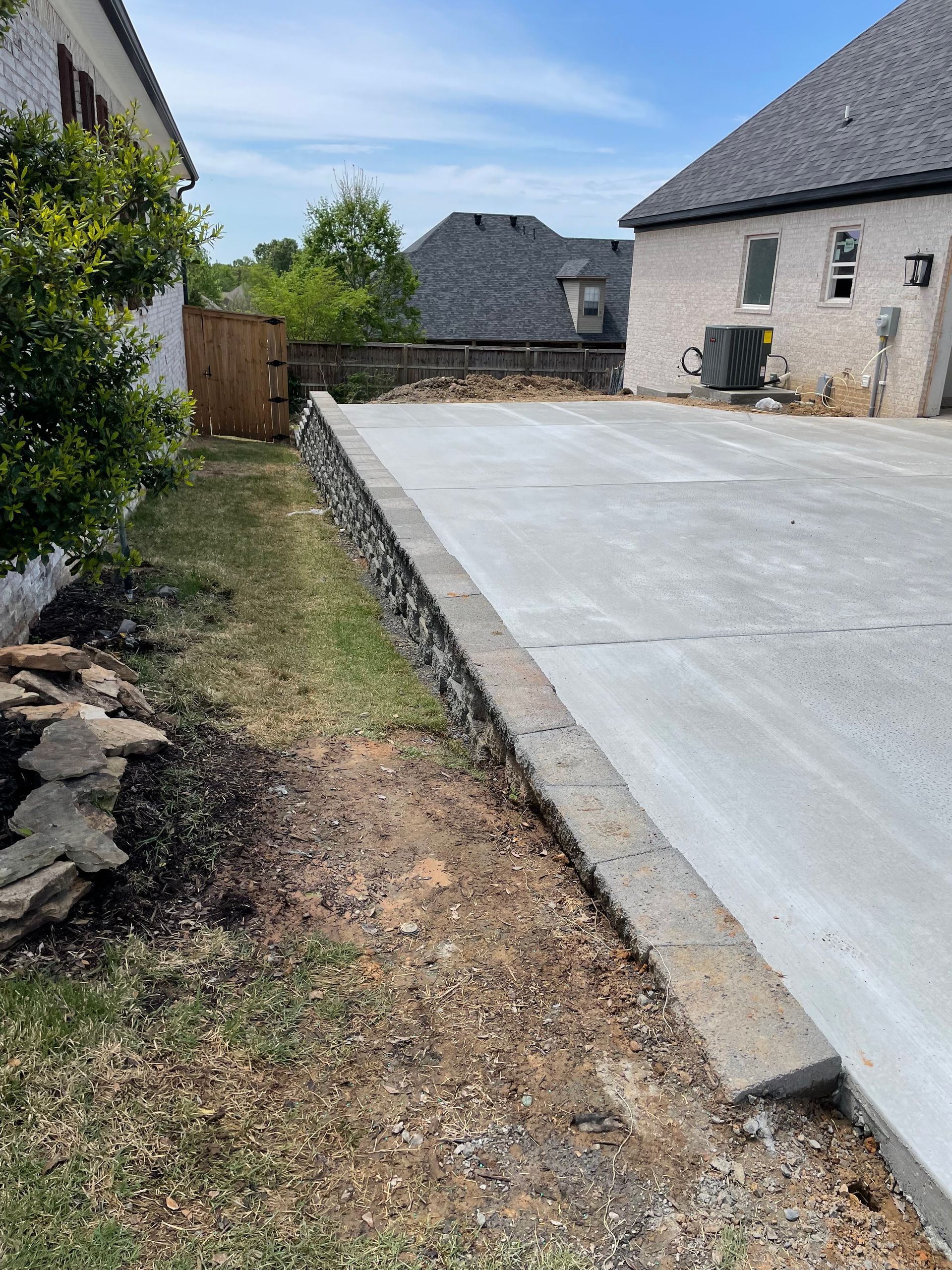 A concrete driveway is being built in the backyard of a house.