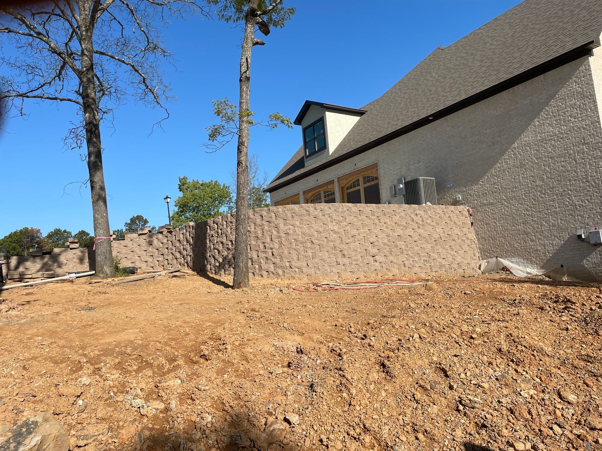 A house is being built in the middle of a dirt field.