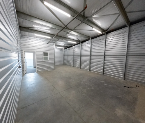 Empty warehouse room with door to office, office door leads outside