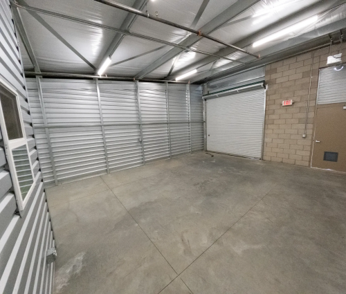 Empty warehouse space with bay door and regular door to outside