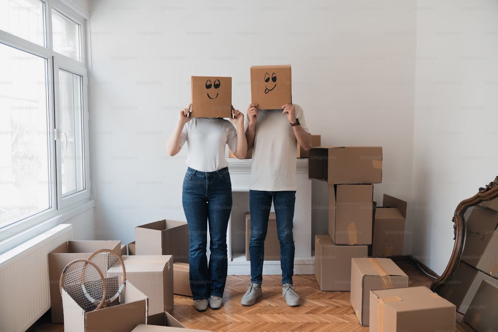 Couple holding boxes while moving