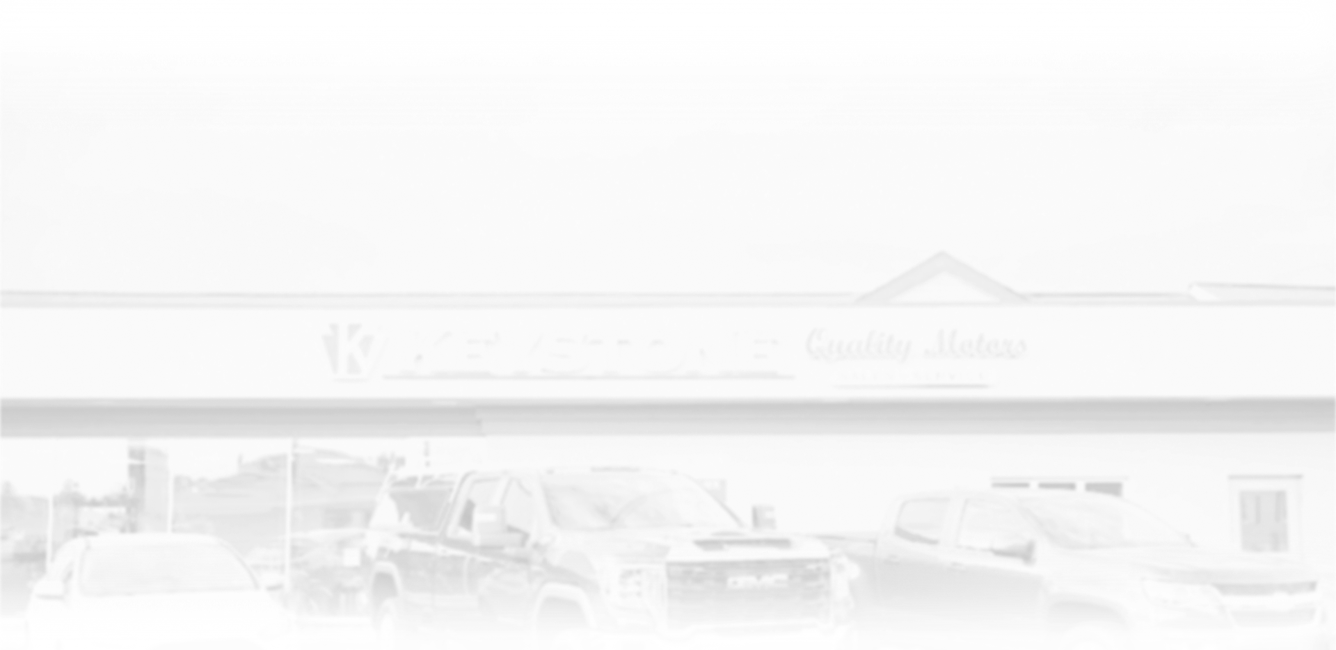 Bright storefront exterior with parked cars in front and a peaked roof sign. | Keystone Quality Motors