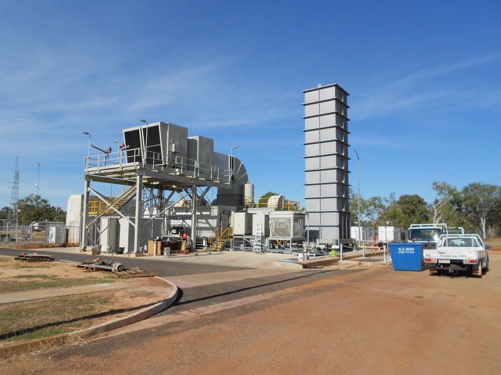 A power station with a tall grey exhaust stack.