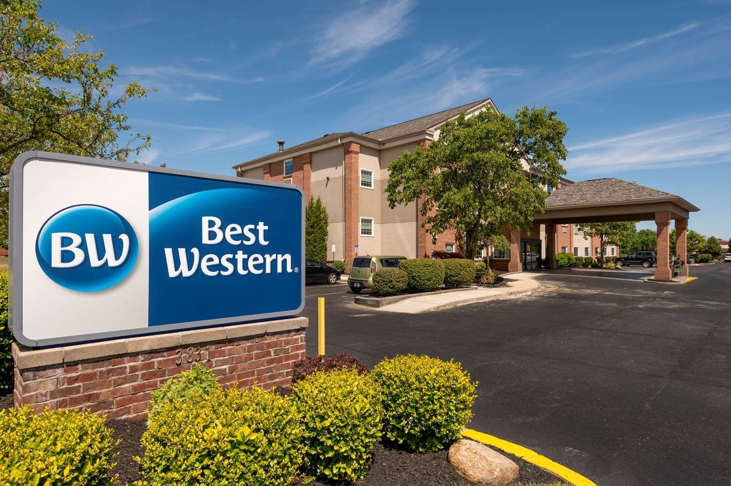 Best Western hotel exterior with sign, landscaping, and covered entrance drive