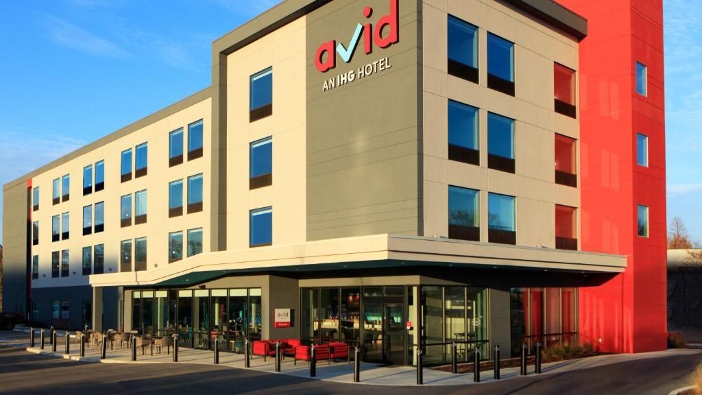 Modern hotel exterior with a red and beige facade and a covered entrance