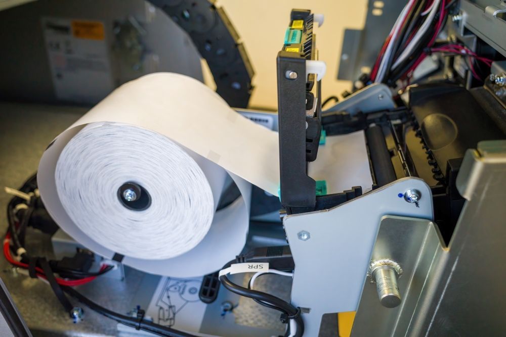 A Roll Of Paper Is Being Pulled Out Of A Machine — Coastal Registers & POS In Ruthven, NSW