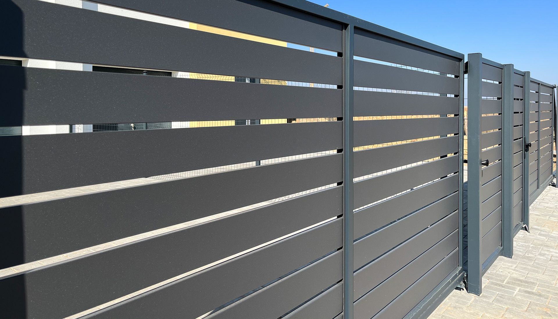 A close up of a fence with a blue sky in the background