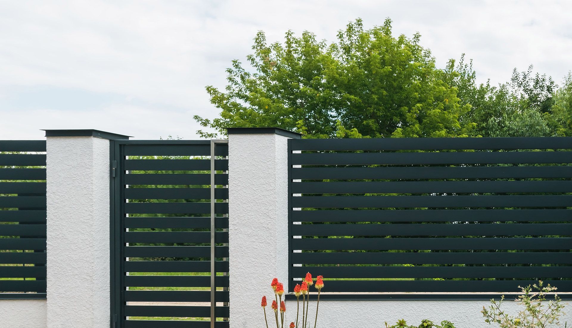 A fence with a gate and trees in the background