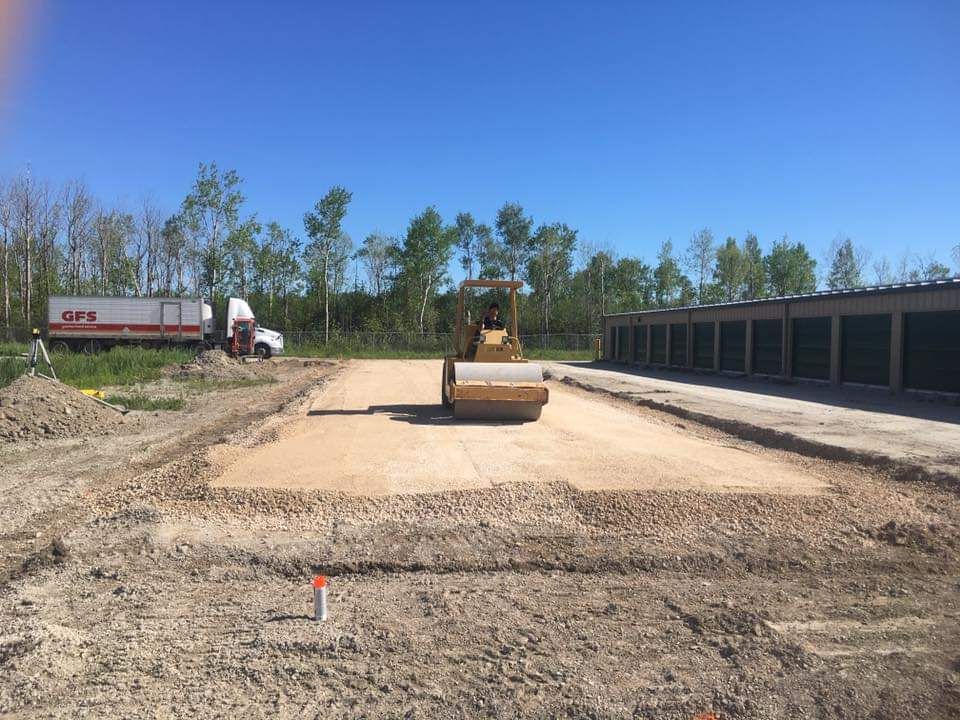 A construction site with a truck in the background and a bulldozer in the foreground.
