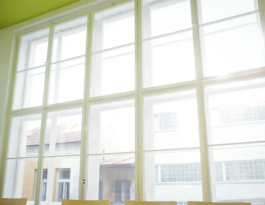 Bright white-framed window overlooking a courtyard and building exterior