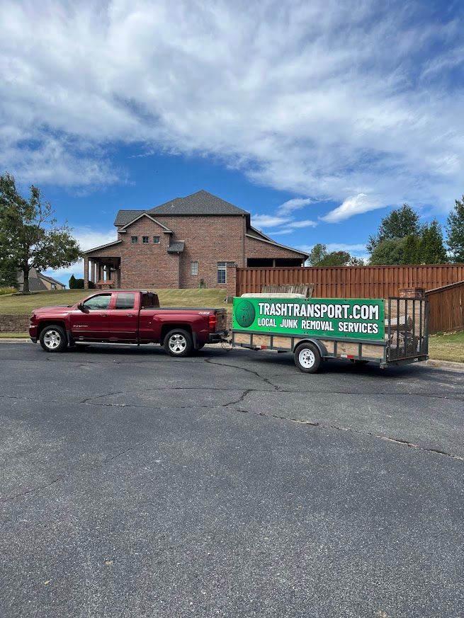 Red truck towing a trailer with a green banner that reads