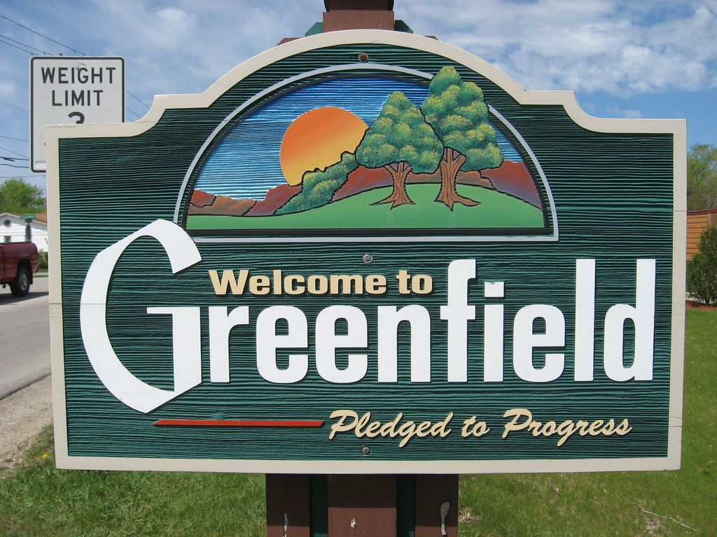 Sign: Welcome to Greenfield, with landscape graphic and 