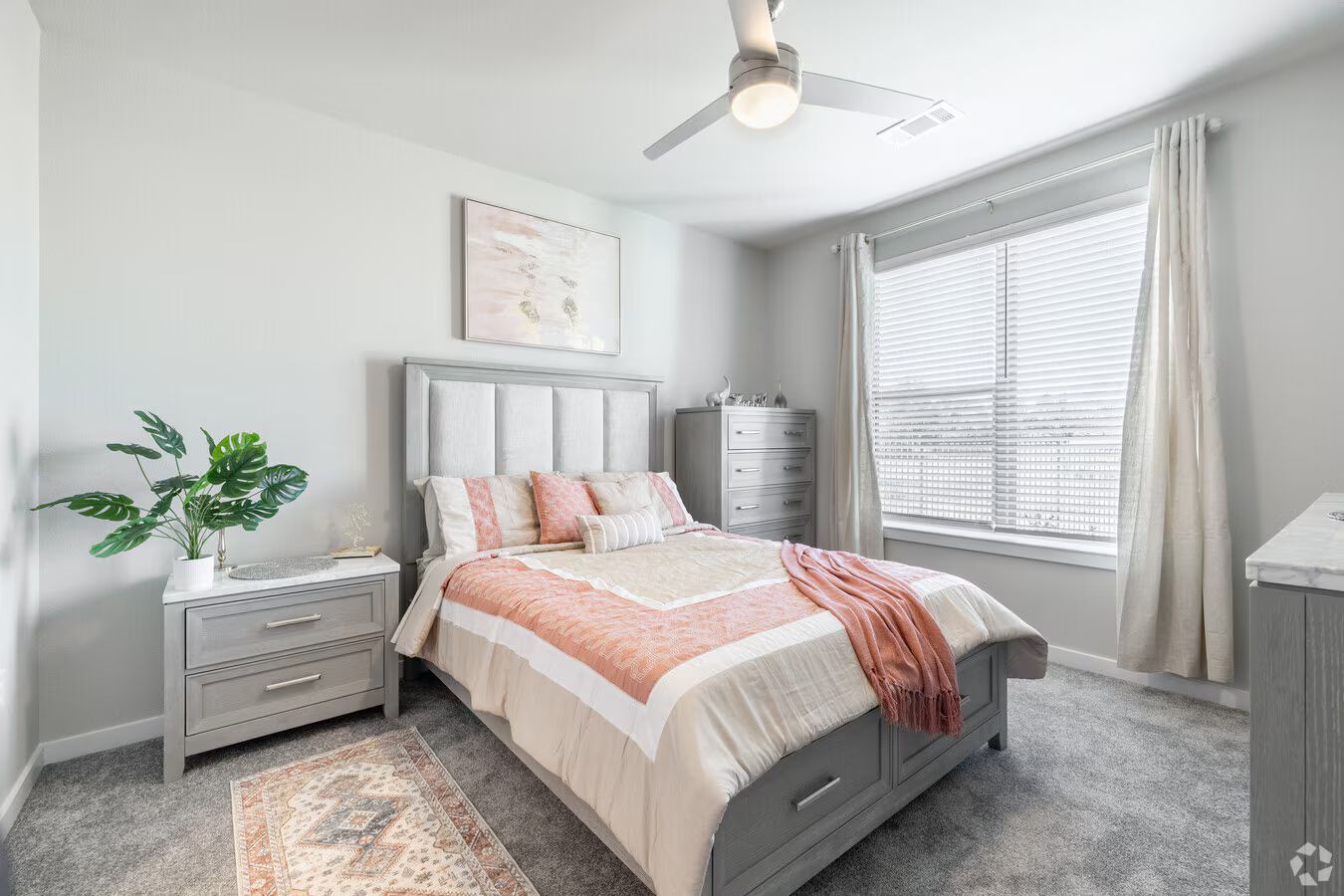 Urban Village at Rosehill apartment bedroom with a window, ceiling fan, and bed.