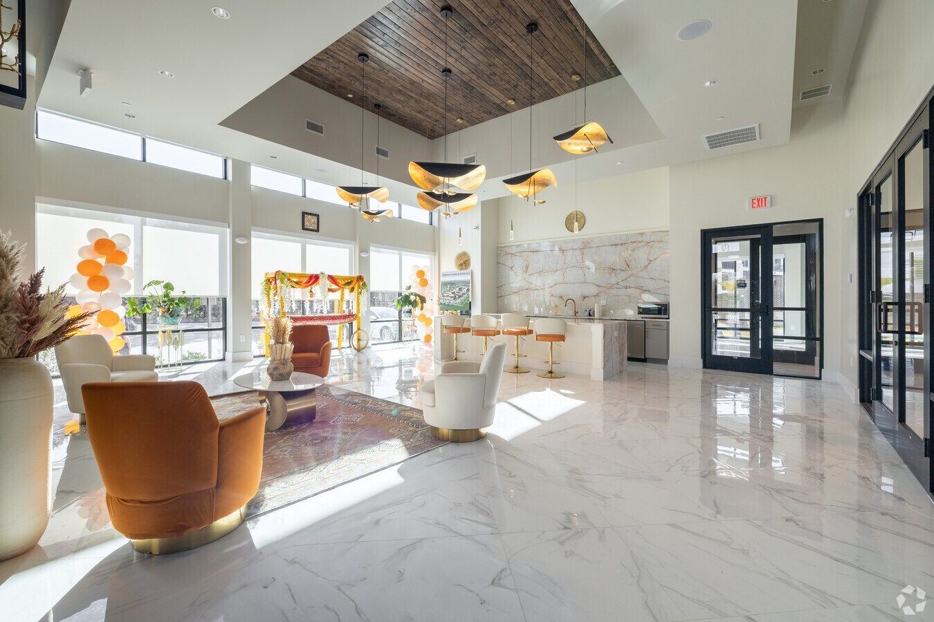 Open-concept living space with kitchen and wood-look flooring at Urban Village at Rosehill, featuring brand-new apartments in Garland, TX. Neutral walls, dark cabinets, and a ceiling fan are visible.