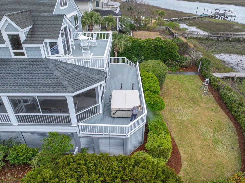 TrueWash technician soft washing the deck of a Sullivan's Island home overlooking the marsh