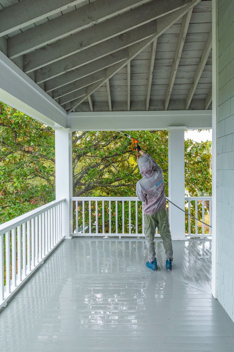 TrueWash technician rinsing a covered porch on a Sullivan's Island home