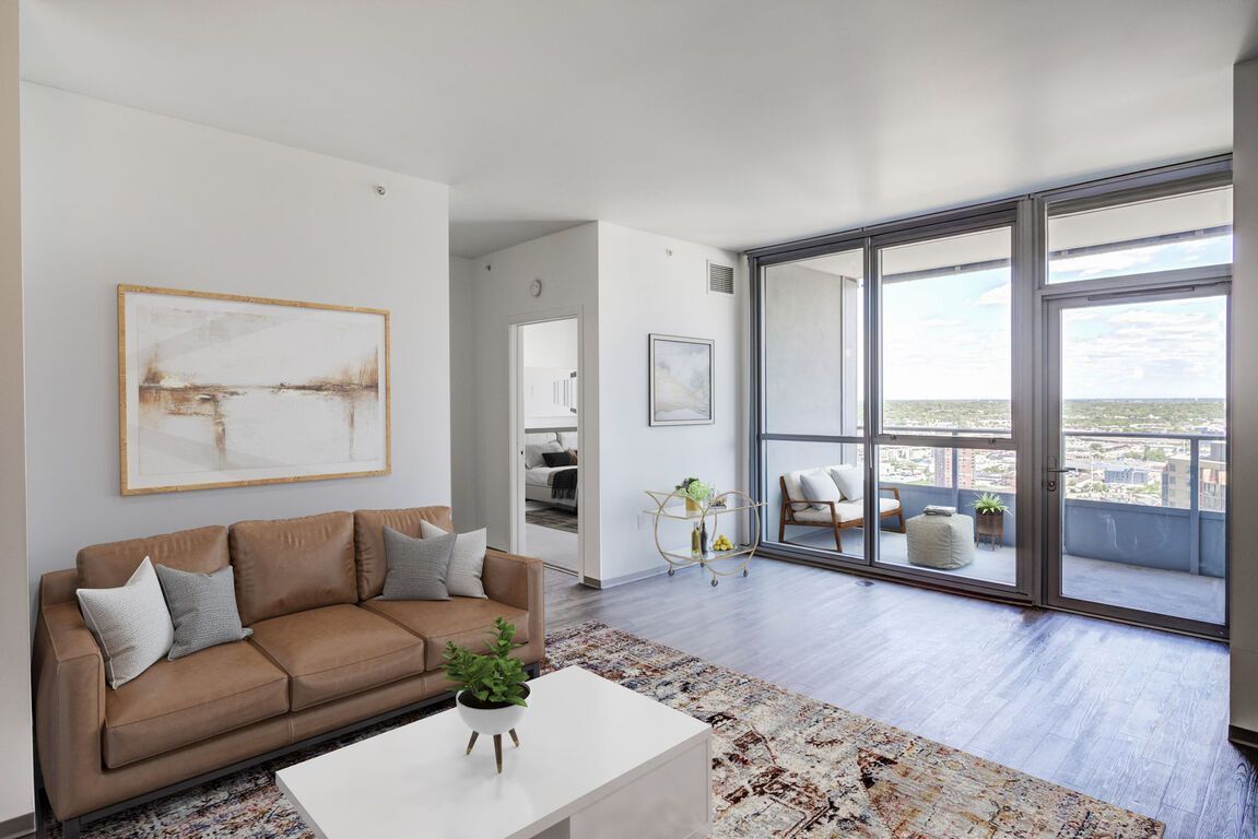 A living room with a brown couch and a white coffee table.