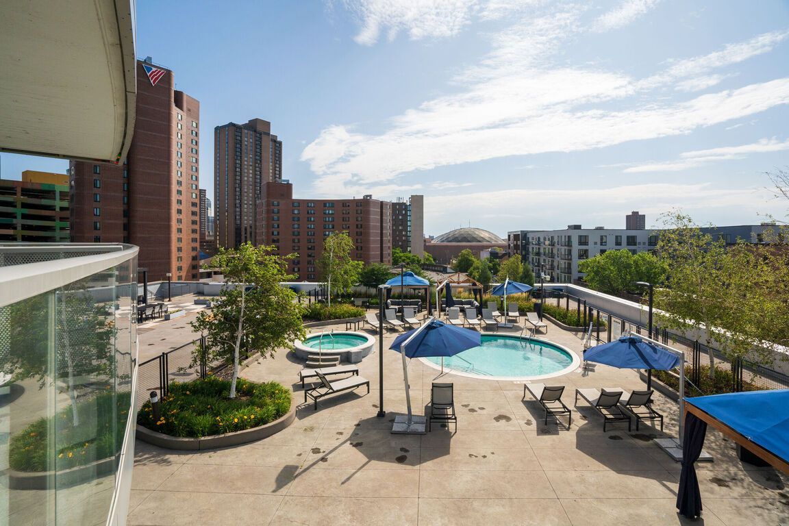 An aerial view of a large swimming pool surrounded by umbrellas and chairs.