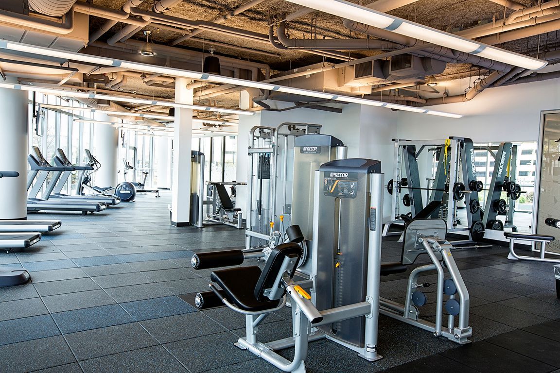 A large gym filled with lots of exercise equipment.