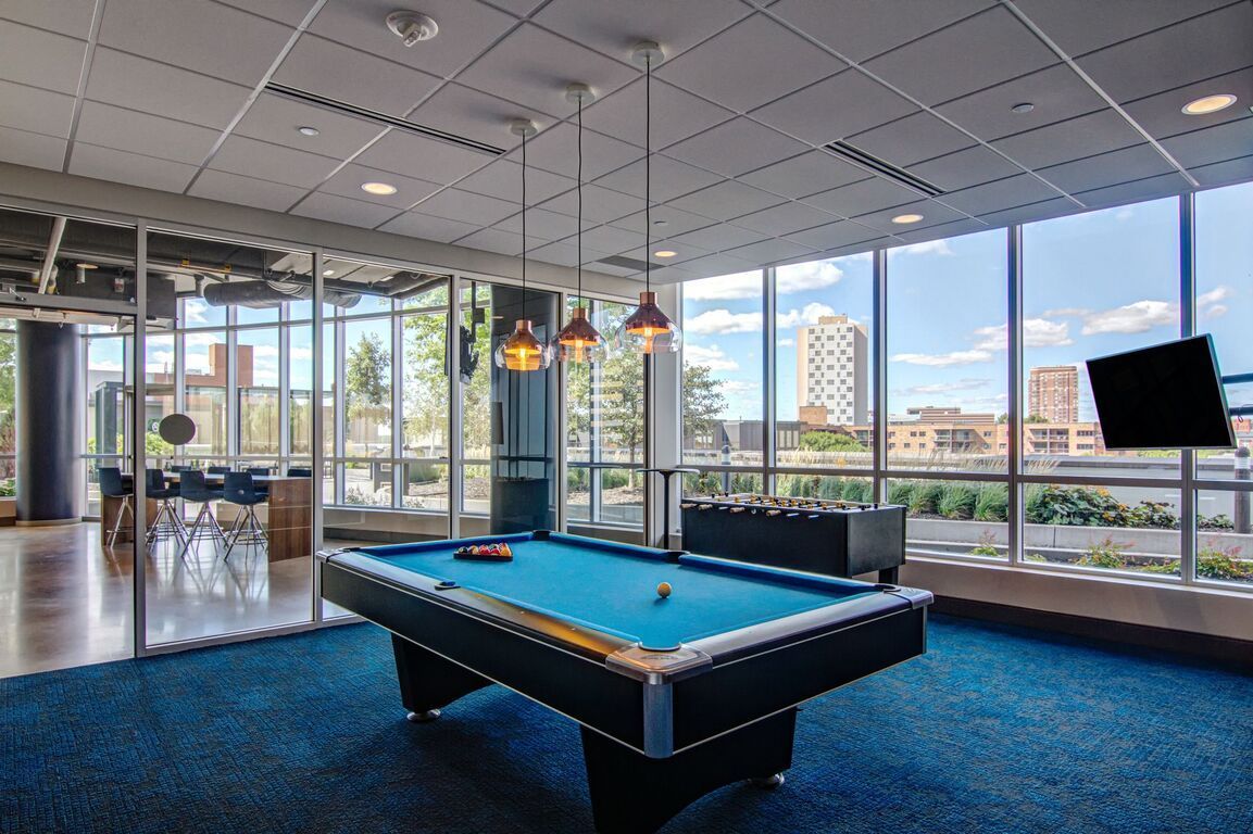 A pool table in a room with a lot of windows