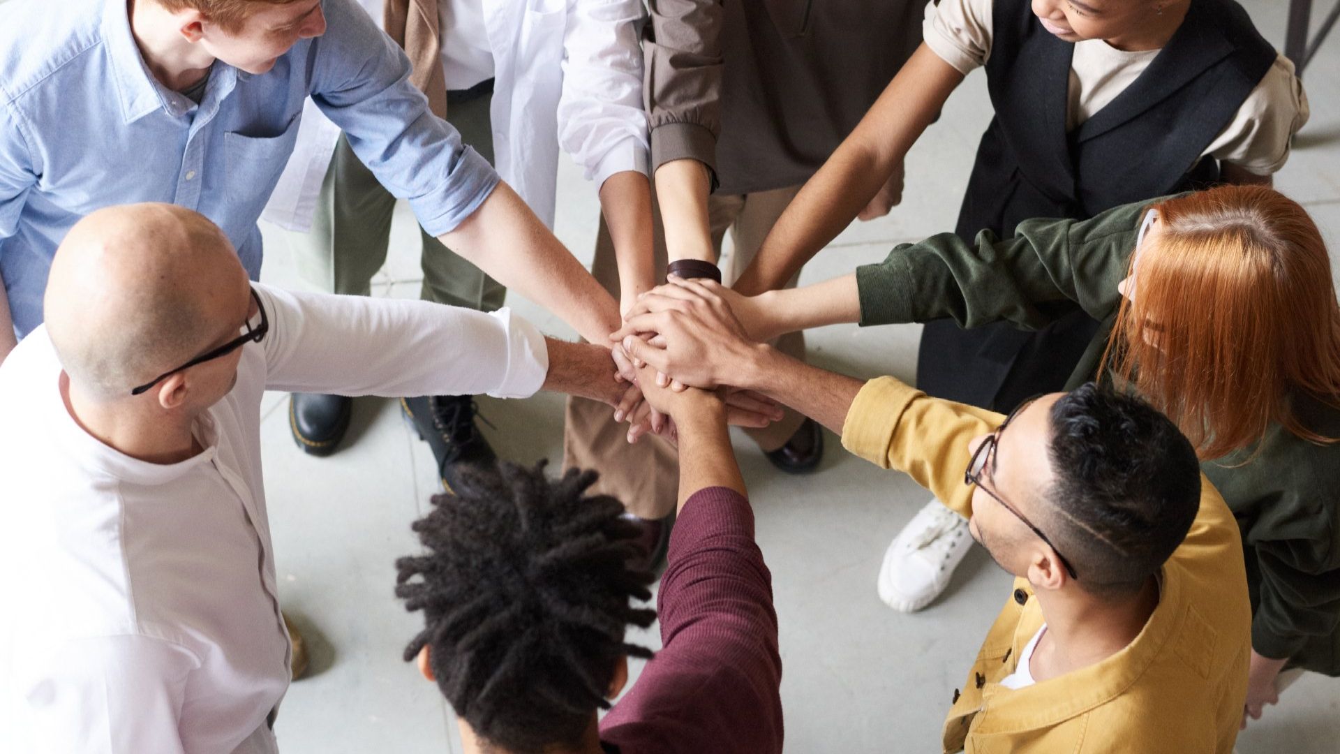 A group of entrepreneurs are putting their hands together in a circle.