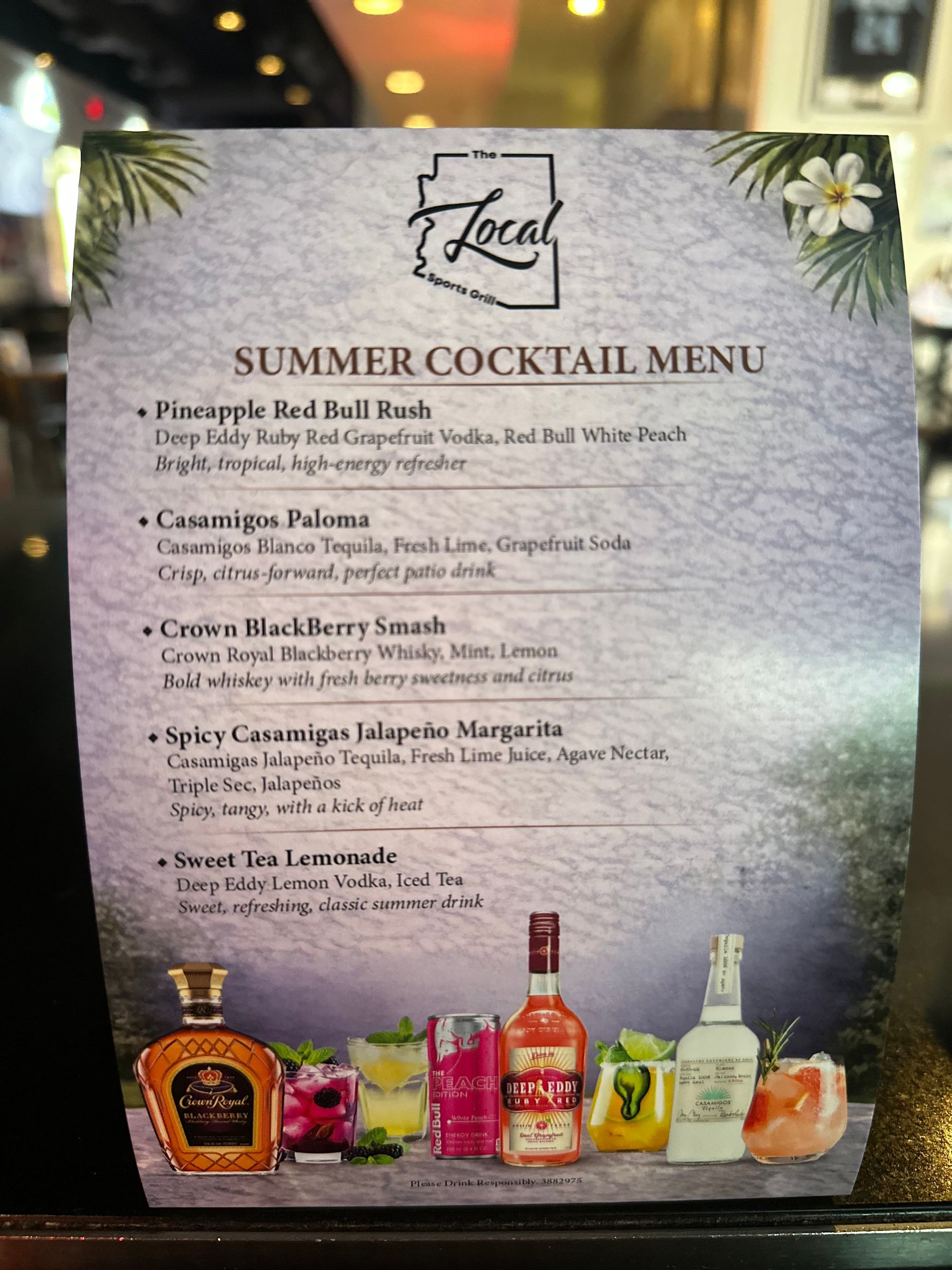 Summer cocktail menu poster with drink list, bottle images, and floral accents on a table sign