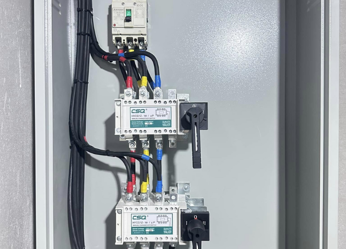 Electrical control panel with circuit breakers and wiring inside a metal cabinet