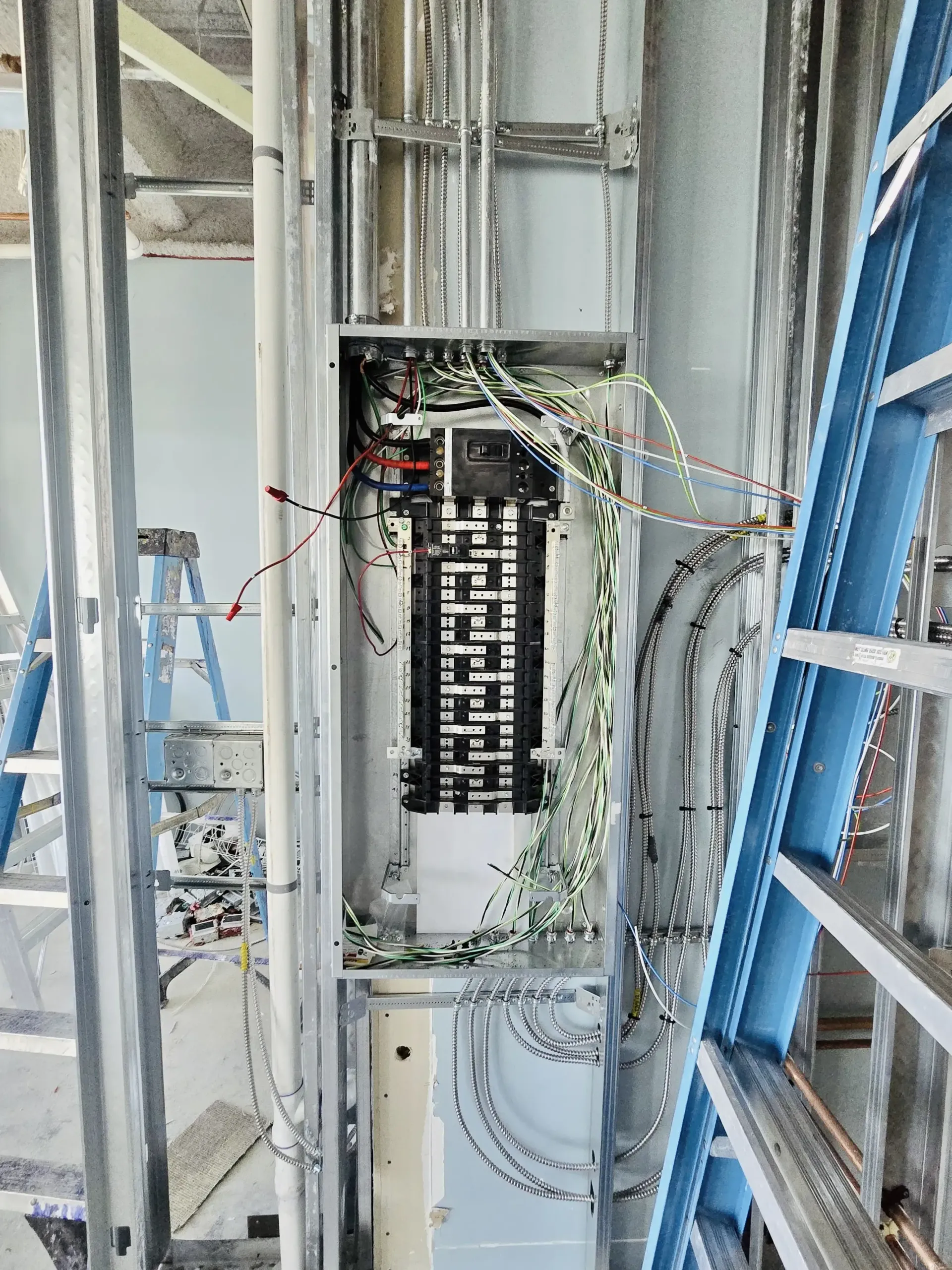 Open electrical panel with exposed wiring in a construction site