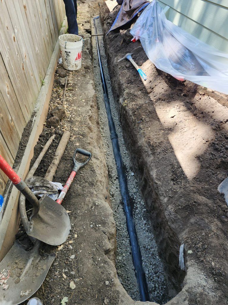 A person is digging a hole in the ground next to a fence.