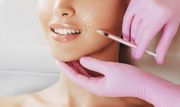Woman’s profile illustration with a facial massage tool applied to the cheek