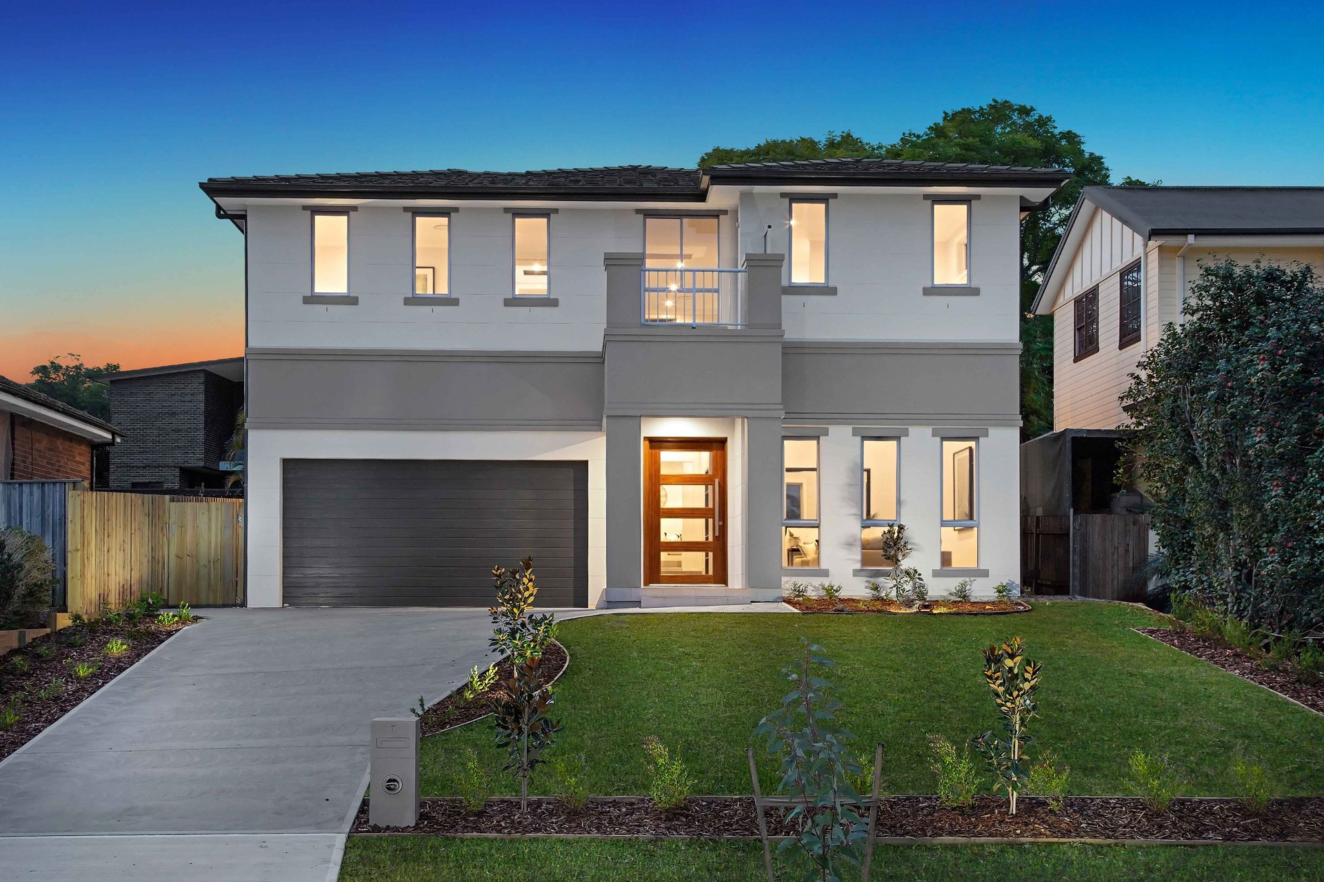 Meadow 42 home design - A front view of a large house with a lot of windows and a garage.