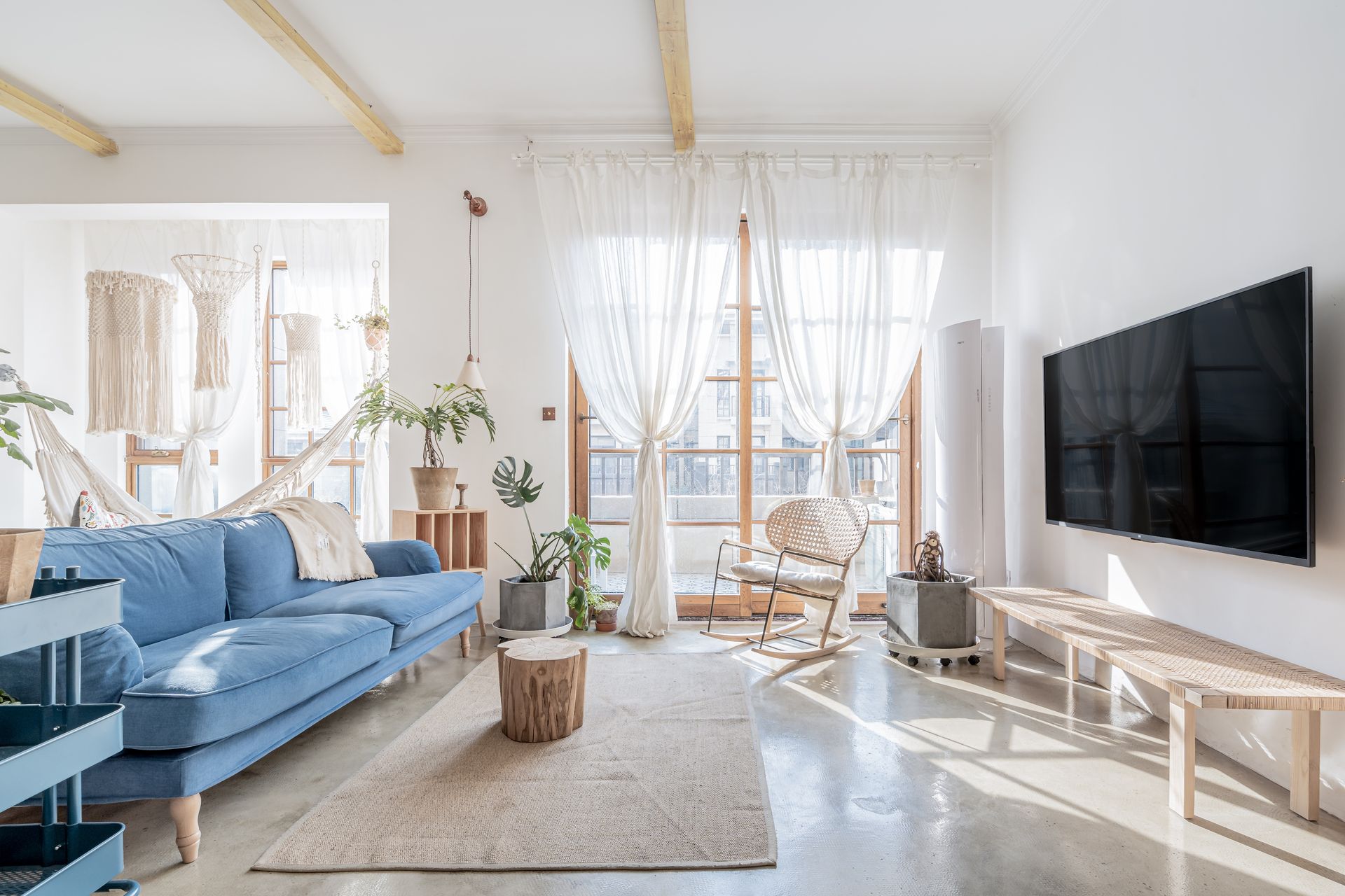Cambridge 24 - White living room with blue couch facing the television.